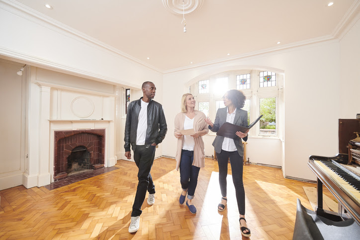 an estate agent shows a couple around a refurbished period home