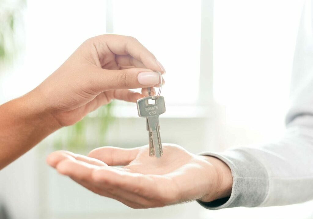 hand handing keys to another hand