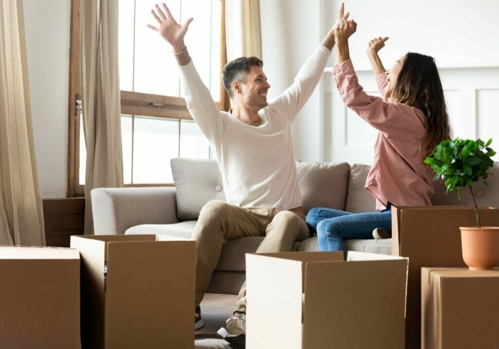 new tenants sitting on couch excited about moving in to rental property